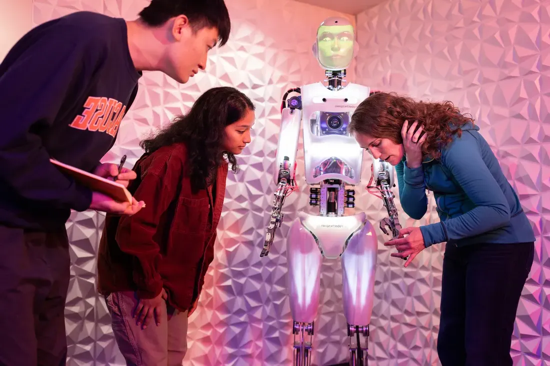 Student with professor working on robot.